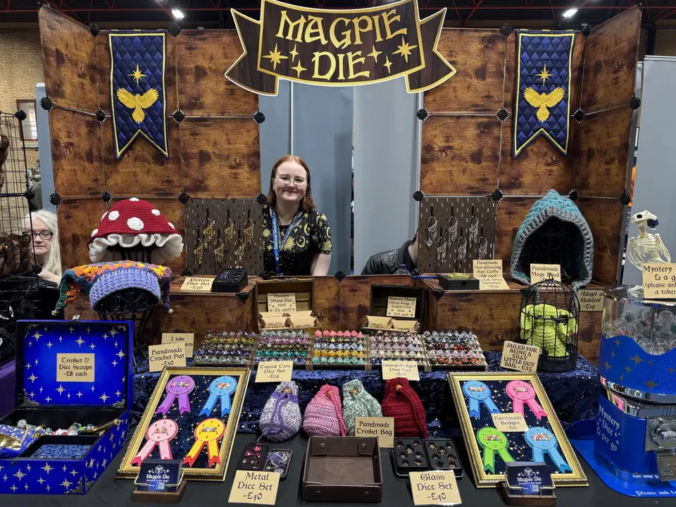 A trader's stand full of dice, dice bags and crochet critters